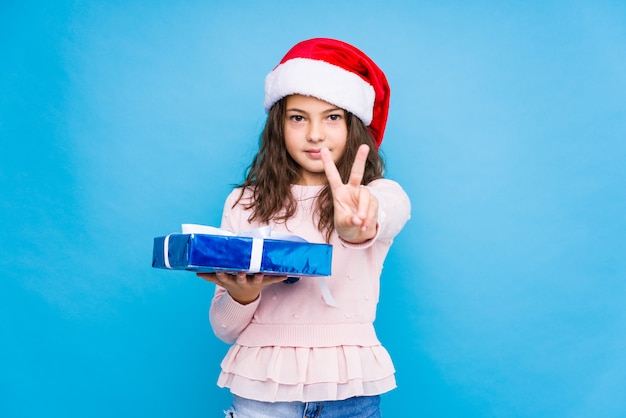 Petite fille tenant un cadeau pour fêter le jour de Noël