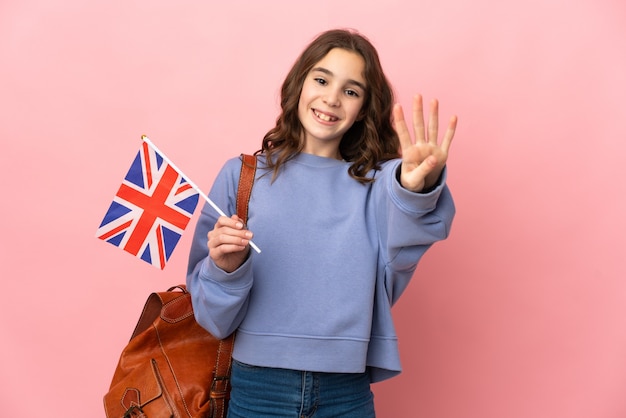 Petite fille tenant un drapeau du Royaume-Uni isolé sur fond rose heureux et en comptant quatre avec les doigts