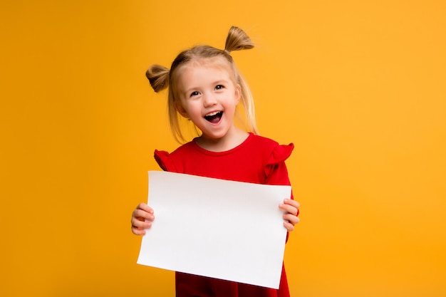 petite fille tenant une feuille blanche.