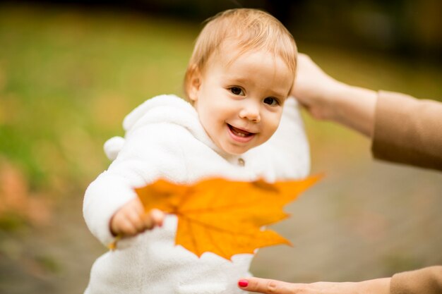 Petite fille tenant une feuille d&#39;érable jaune