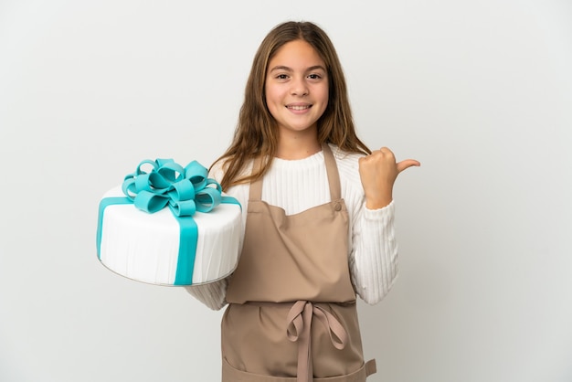 Petite fille tenant un gros gâteau