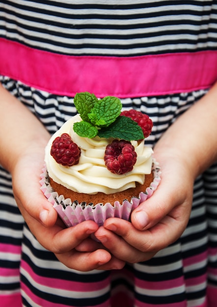 Petite fille tenant un petit gâteau