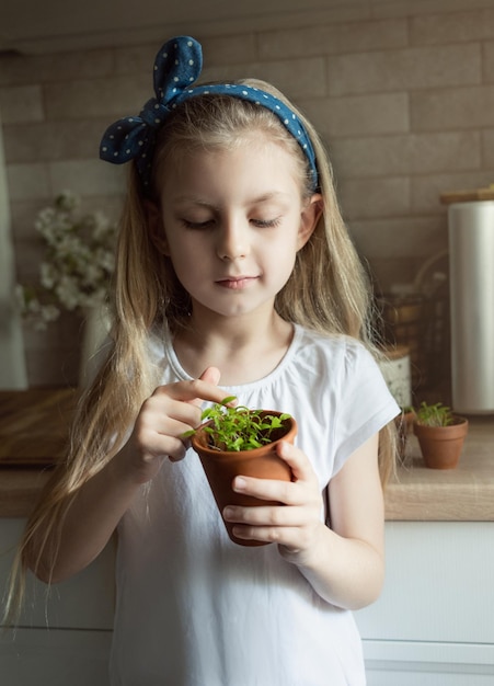 Petite fille tenant un pot de semis