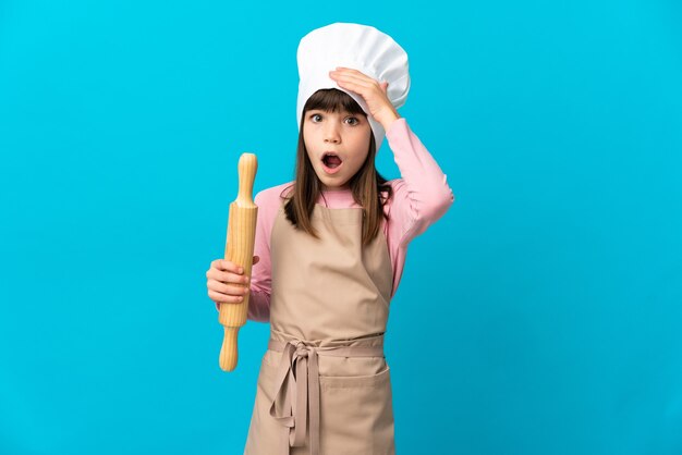 Petite fille tenant un rouleau à pâtisserie isolé