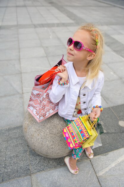 Petite fille tenant des sacs à provisions