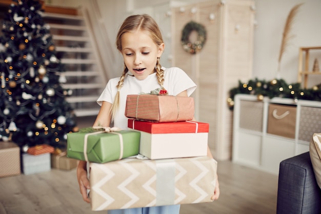 Petite fille tenant des tas de cadeaux