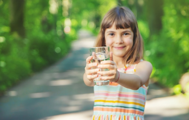 Petite fille tenant un verre d'eau