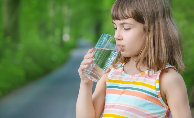 Petite fille tenant un verre d'eau