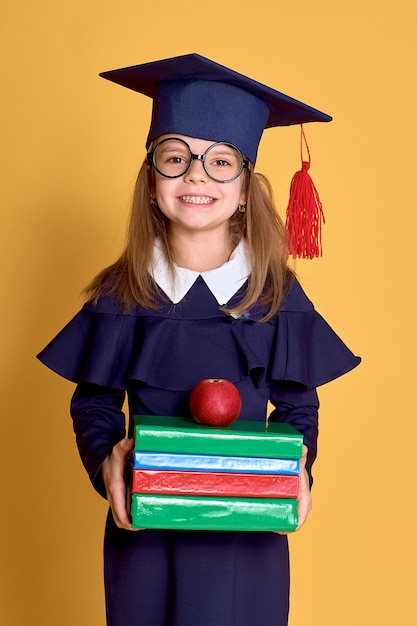 Petite fille en tenue d'académicien avec livre