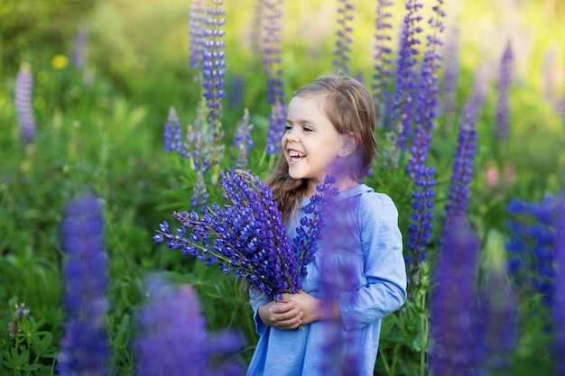 Petite fille sur le terrain avec des fleurs violettes