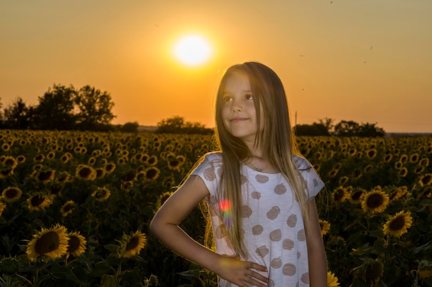 Petite fille sur le terrain avec des tournesols arrière-plan flou