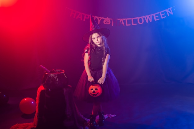 Petite fille tient jack citrouille sur halloween vacances kid girl porter costume de sorcière conte de fées fantastique