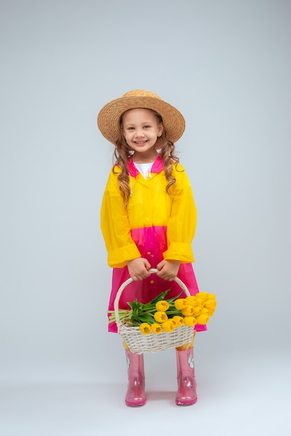 Petite fille tient un panier de fleurs