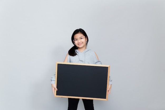 Une petite fille tient un tableau blanc