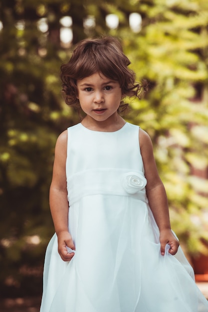 Petite fille tournant en robe ornée en plein air