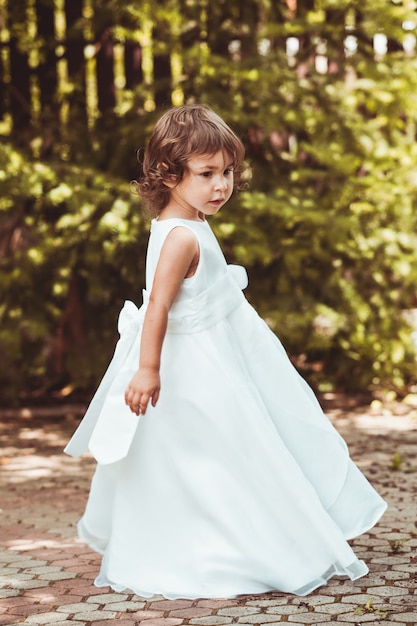 Petite fille tournant en robe ornée en plein air