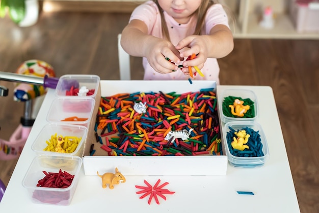 Petite Fille Tout-petit Jouant Avec Un Bac Sensoriel Avec Des Pâtes  Colorées Colorées Activité De