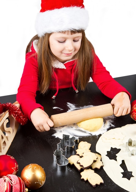 Petite fille en train de cuisiner des biscuits de Noël