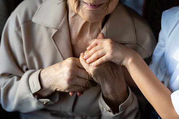 Petite fille et très vieille femme. Petit enfant étreignant la grand-mère. Petite fille