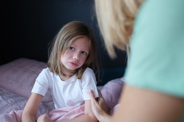 La petite fille triste bouleversée communique avec la maman à la maison