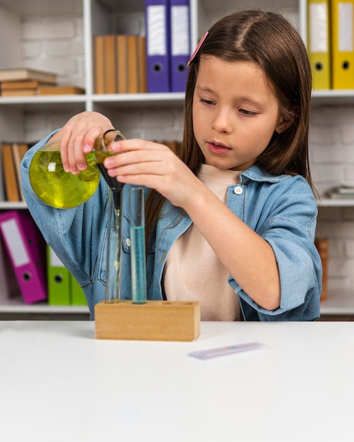 Photo petite fille avec tubes à essai et microscope