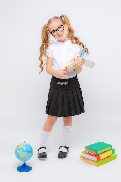 Une Petite Fille En Uniforme Scolaire Et Lunettes Tient Un Globe Dans Ses Mains Sur Un Espace Blanc