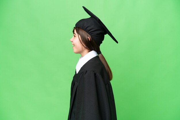 Petite fille universitaire sur fond isolé riant en position latérale