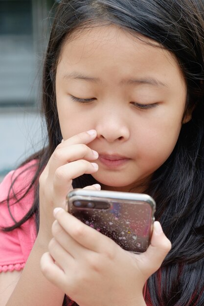 Petite fille utilisant un smartphone en studio