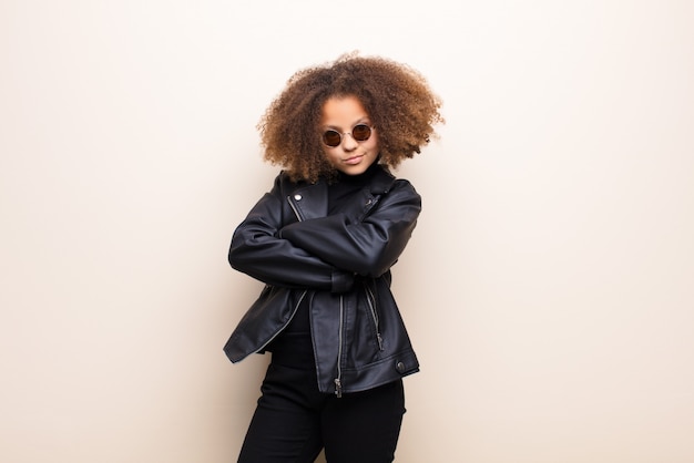 Petite fille avec veste en cuir noir et lunettes de soleil