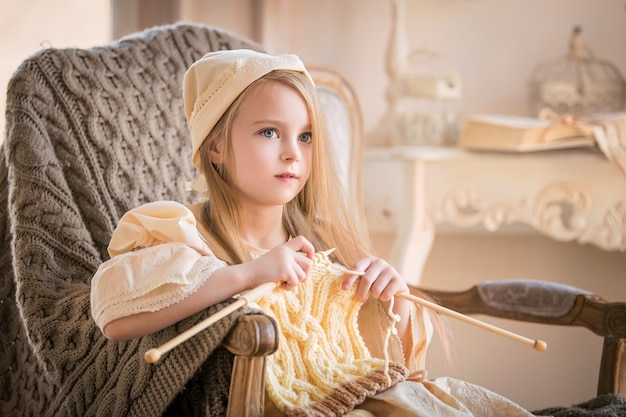 Petite fille en vêtements vintage légers à tricoter