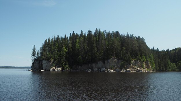 Photo une petite île avec des arbres dessus et un bateau dans l'eau.