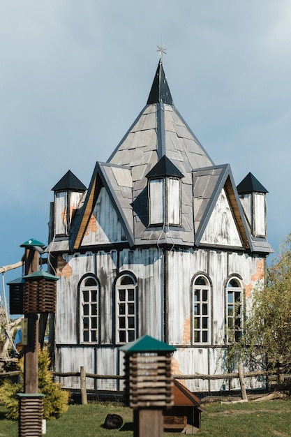 Une petite maison blanche au toit pointu se dresse dans la rue