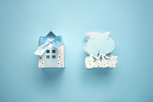 Petite maison bleue en papier et jouet en bois pour enfants avec ballons sur le fond bleu