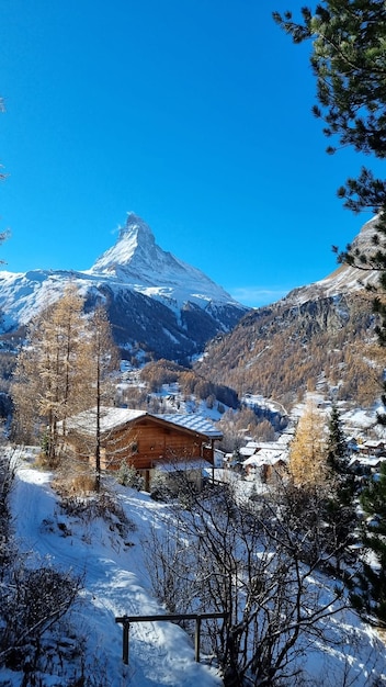 Une petite maison en bois dans les montagnes avec la neige sur le toit