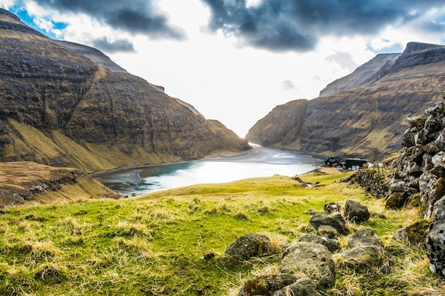 Une petite maison est située sur une colline surplombant un lac.