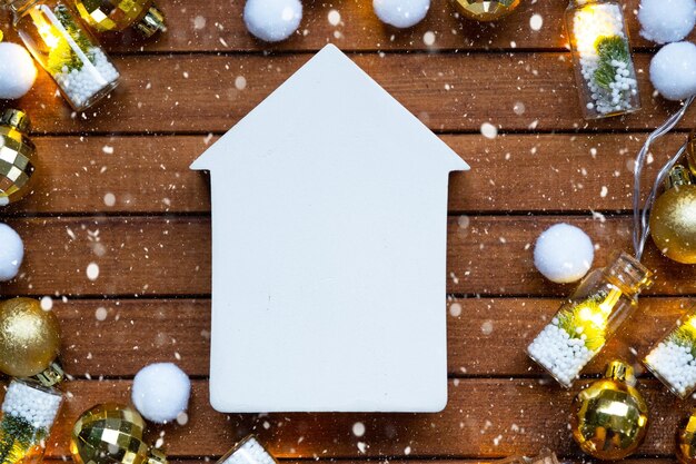 Petite maquette de maison blanche sur fond en bois avec disposition de décoration de Noël et copie d'un immeuble spatial