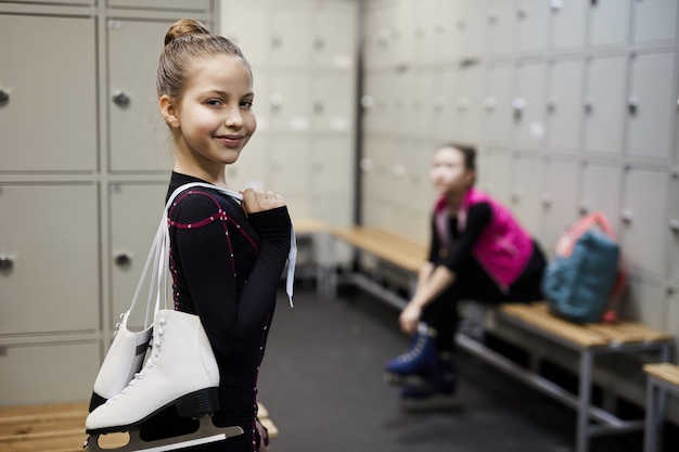 Petite patineuse artistique dans un vestiaire