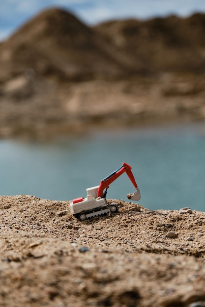 Petite pelle en plastique avec godet travaillant sur l'extraction de sable à la carrière