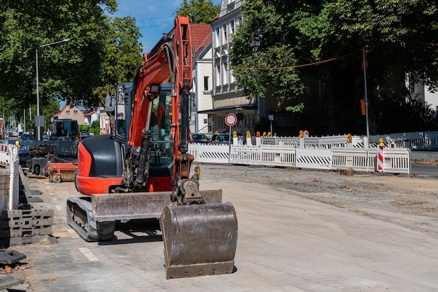 Petite pelle rouge debout sur un chantier de construction