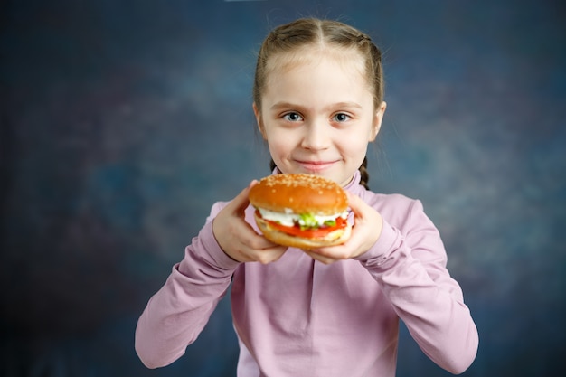 Petite petite fille mangeant un hamburger, après la restauration rapide - Image