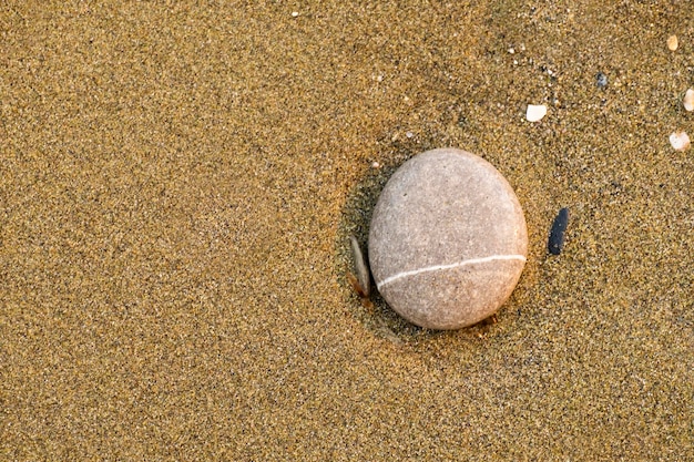 Une petite pierre arrondie par l'érosion du sable et des vagues