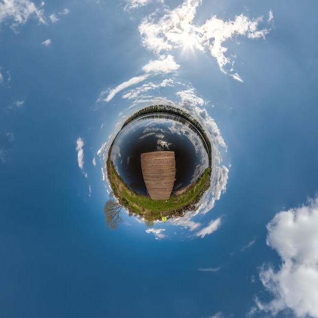 Petite planète dans un ciel couvert bleu avec de beaux nuages avec transformation du panorama sphérique à 360 degrés Vue aérienne abstraite sphérique Courbure de l'espace