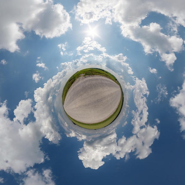 Petite planète dans un ciel couvert bleu avec de beaux nuages avec transformation du panorama sphérique à 360 degrés Vue aérienne abstraite sphérique Courbure de l'espace