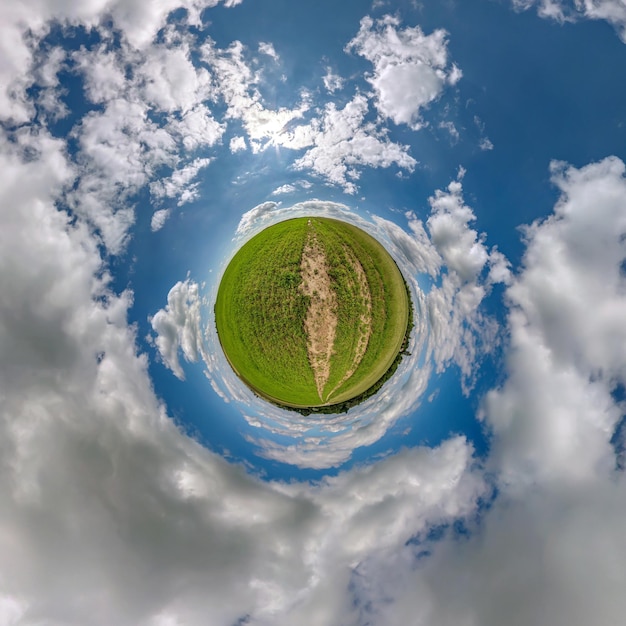 Petite planète verte dans le ciel bleu avec de beaux nuages Transformation du panorama sphérique à 360 degrés Vue aérienne abstraite sphérique Courbure de l'espace