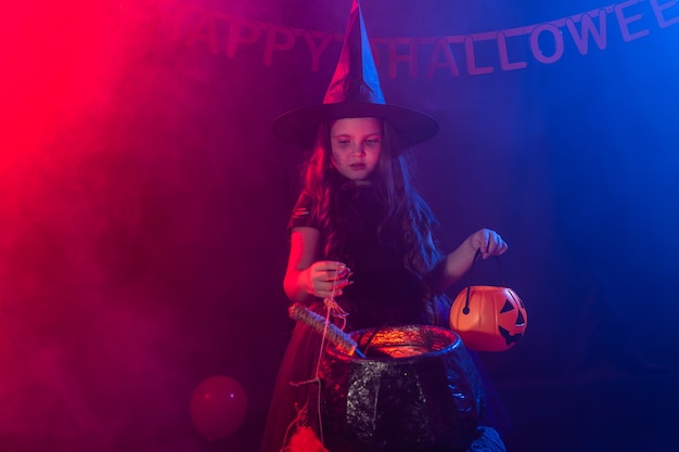 Petite potion de cuisine d'enfant de sorcière dans le chaudron à l'halloween