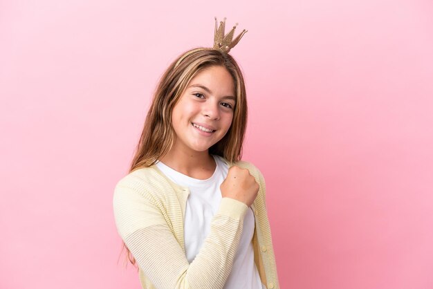 Petite princesse avec couronne isolée sur fond rose célébrant une victoire