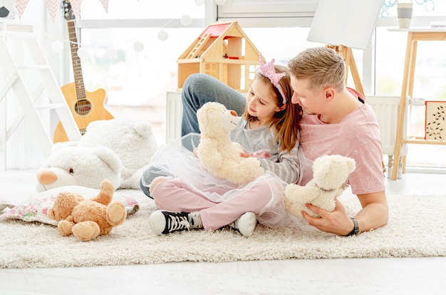 Petite princesse jouant avec père souriant