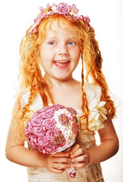 Petite princesse posant avec bouquet de roses artificielles