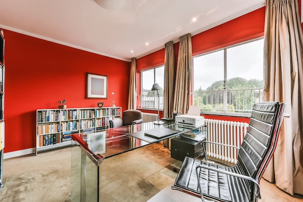 Petite salle de bureau avec des murs rouges et quelques meubles