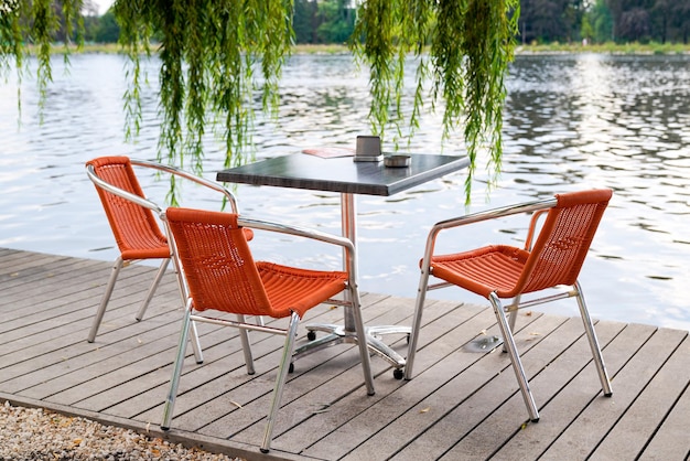 Petite table de bar extérieure sur le ponton en bois au bord de la rivière